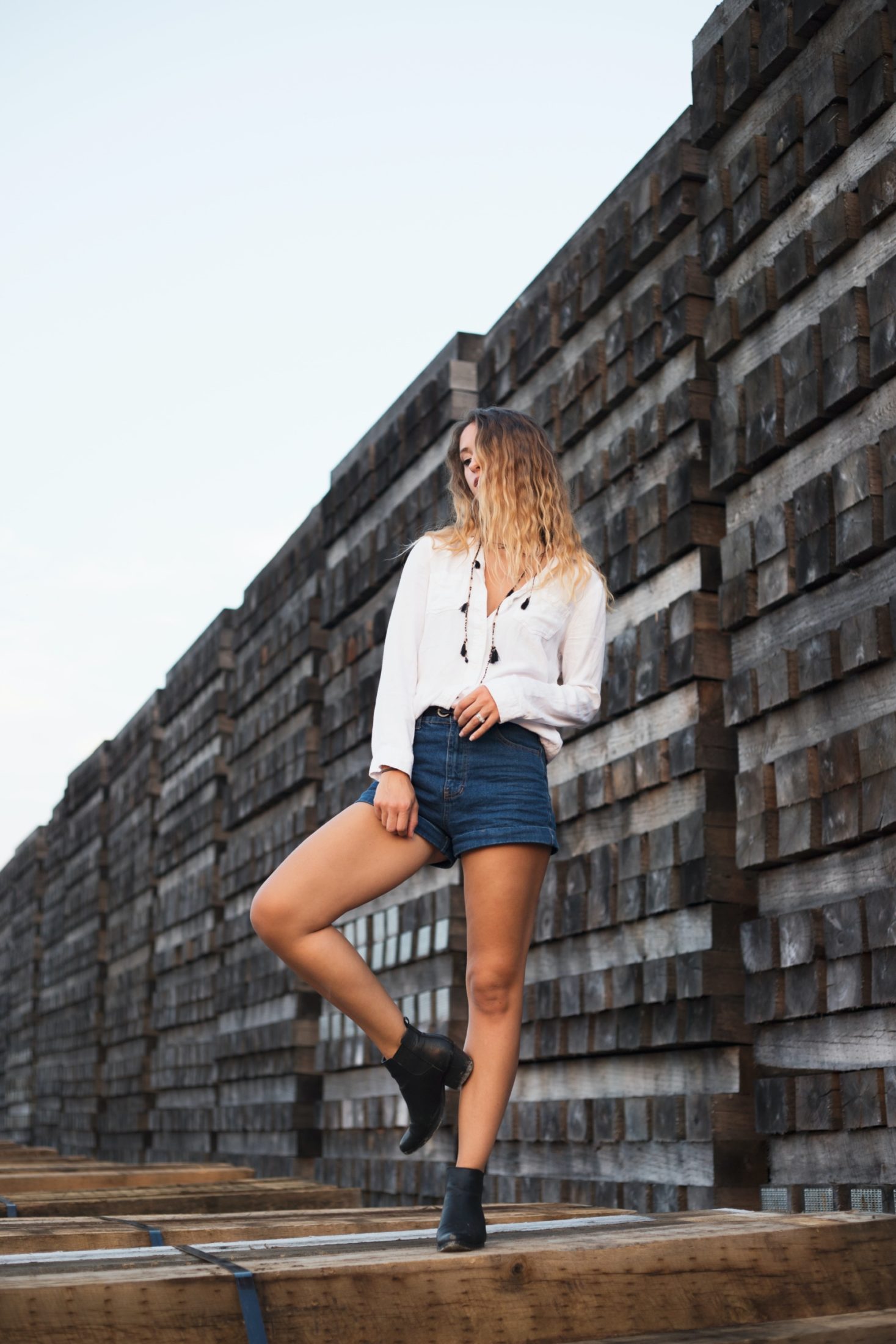 woman in white dress shirt and blue denim shorts
